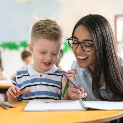 A student and teacher smiling together