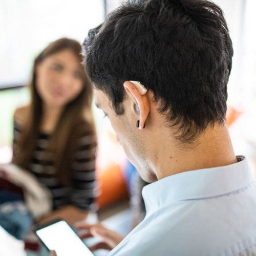 A young man with hearing aids in class